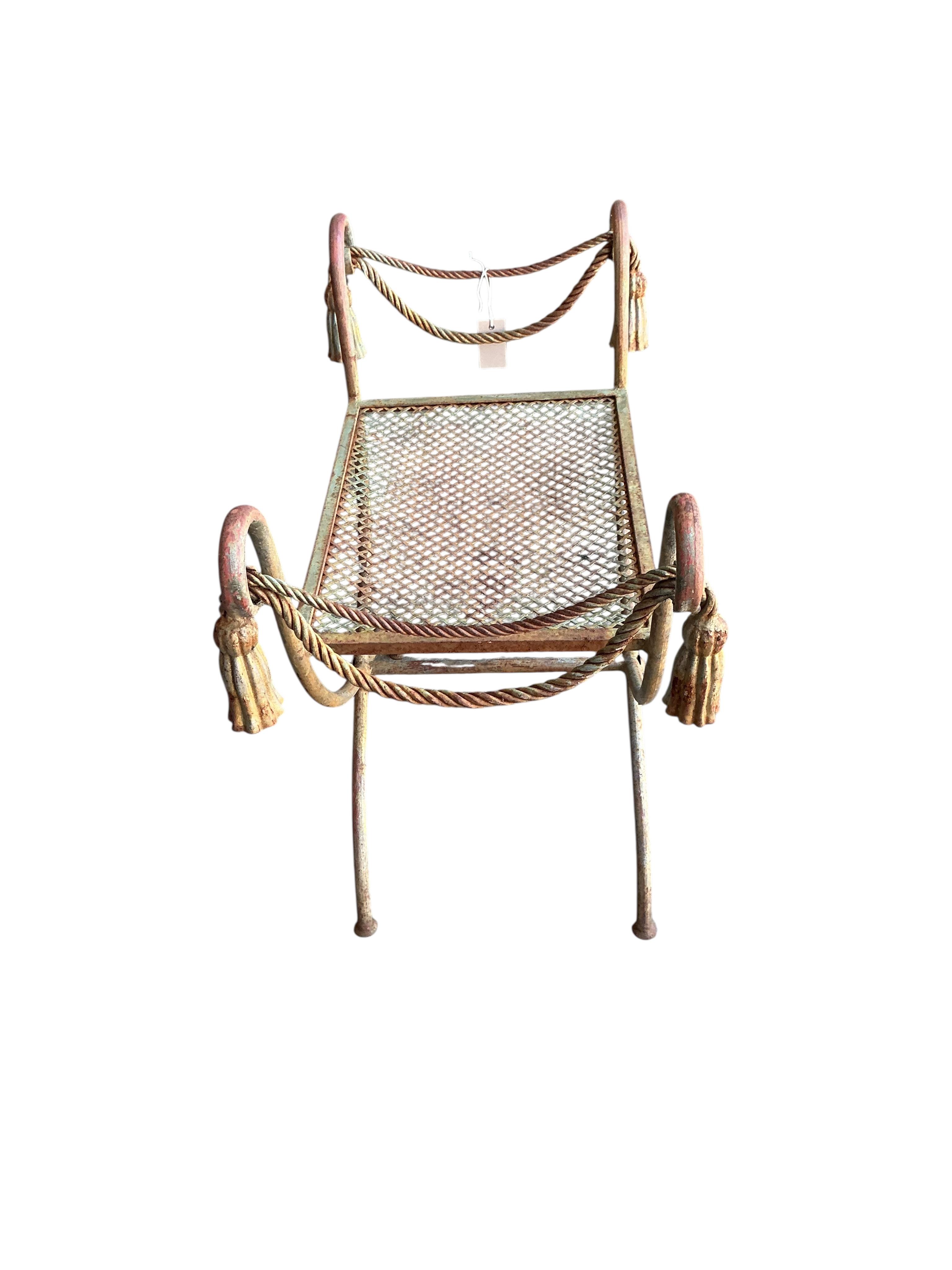 A wrought iron X-framed stool, width 71cm, depth 40cm, height 61cm